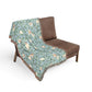 Floral patterned throw blanket draped over a brown chair on a white background