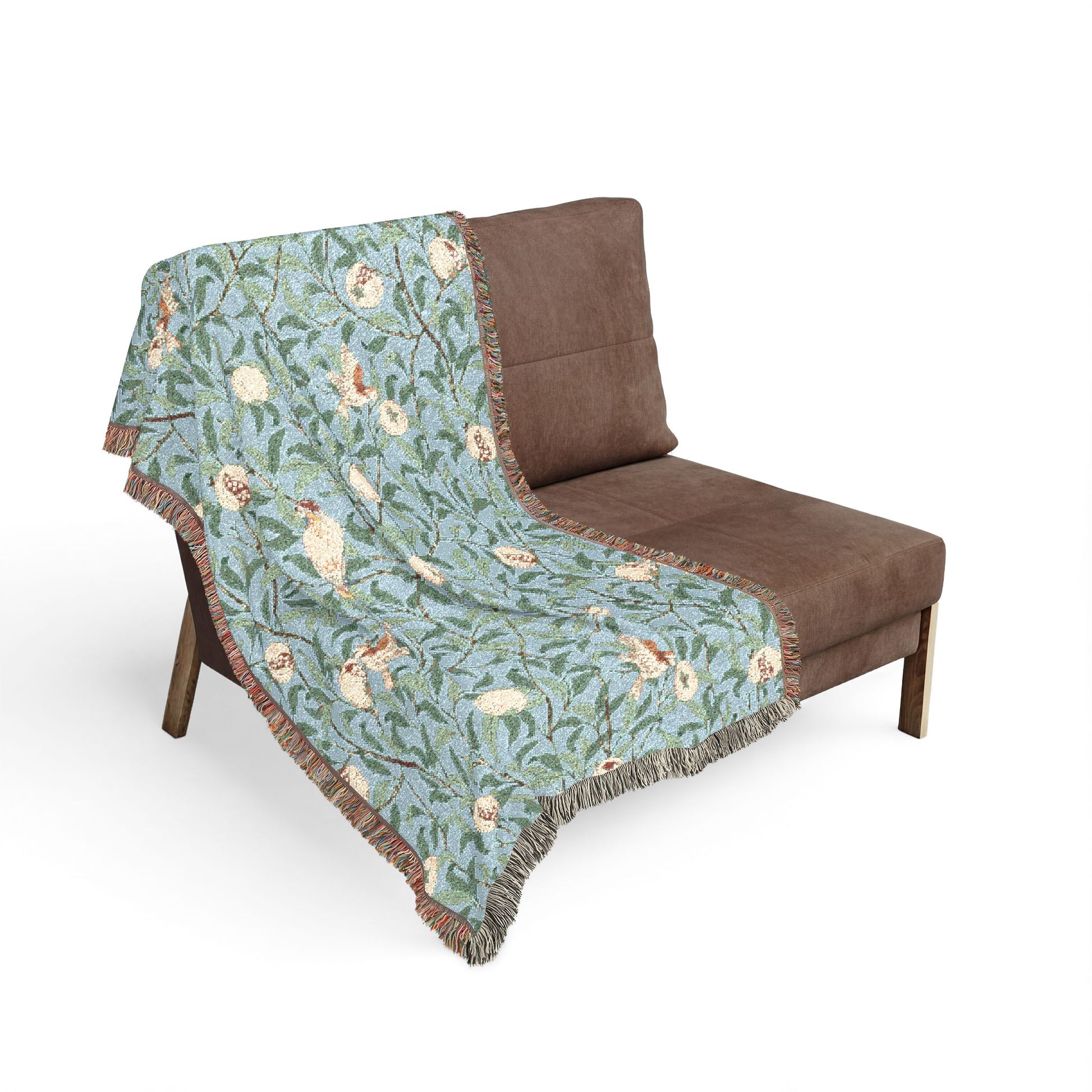 Floral patterned throw blanket draped over a brown chair on a white background