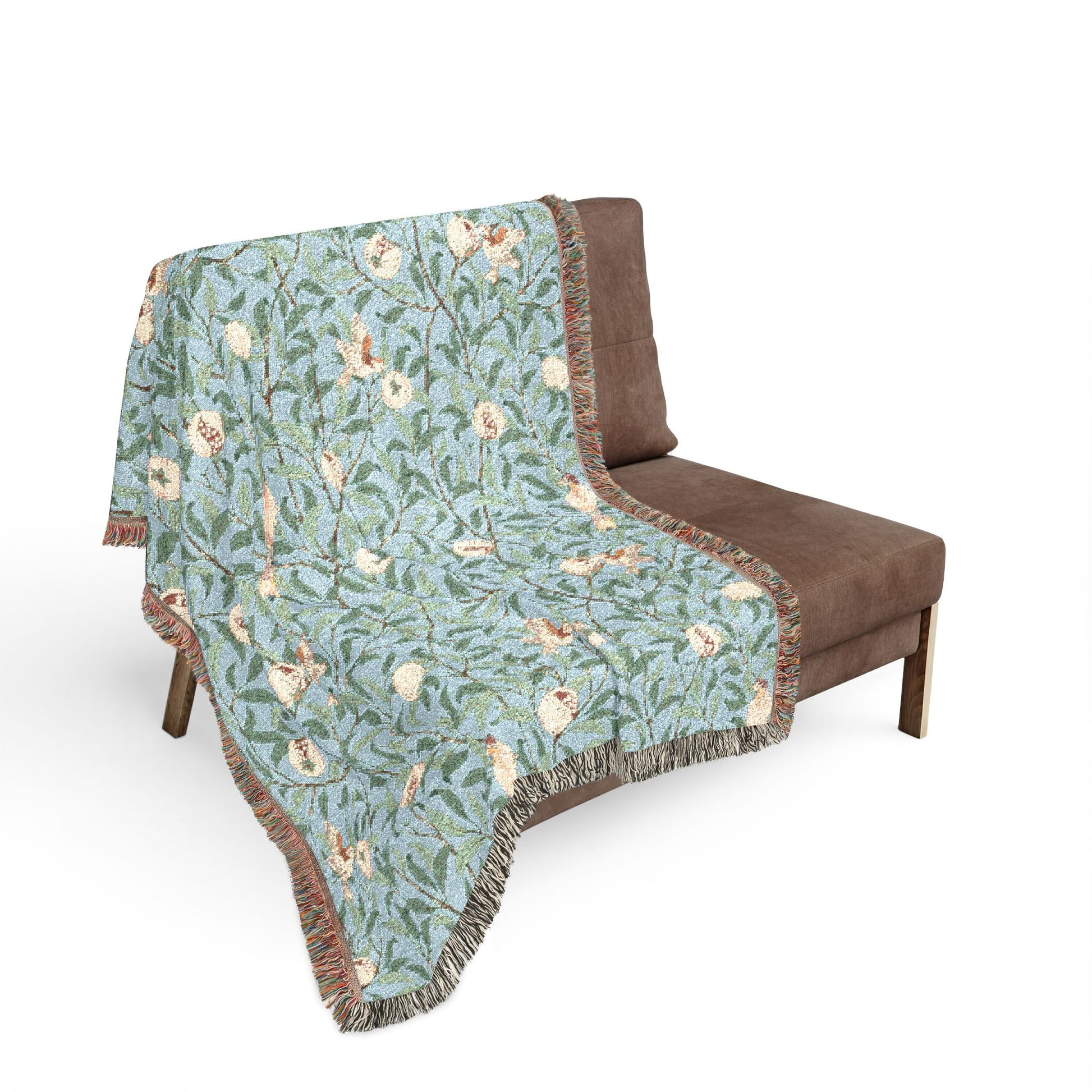 Floral patterned throw blanket draped over a brown chair on a white background