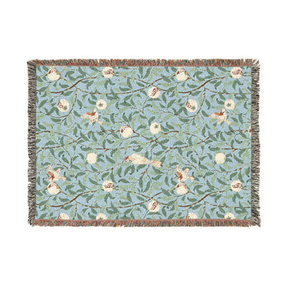 Decorative throw blanket with floral and bird pattern on a light blue background
