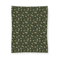 Patterned fabric with small animal and plant design on a green background