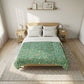Bed with green floral comforter in a bright bedroom