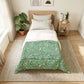 Bedroom with a bed featuring a green floral patterned comforter, wooden nightstand, and plants.