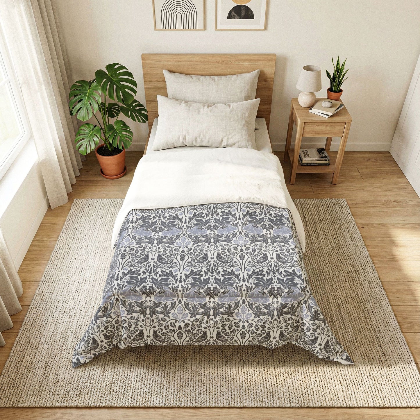 Bedroom with a bed featuring a gray and white patterned comforter, nightstand, and plants.