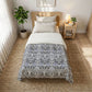 Bedroom with a bed featuring a floral patterned comforter, nightstand, and plants.