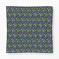 A square fabric item, likely a bandana or scarf, featuring a dense repeating pattern of blue flowers, green leaves, and small cream-colored rabbits on a dark green background.