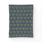 A rectangular fabric item, likely a pillowcase or small blanket, featuring a dense repeating pattern of blue flowers, green leaves, and small cream-colored rabbits on a dark teal background.