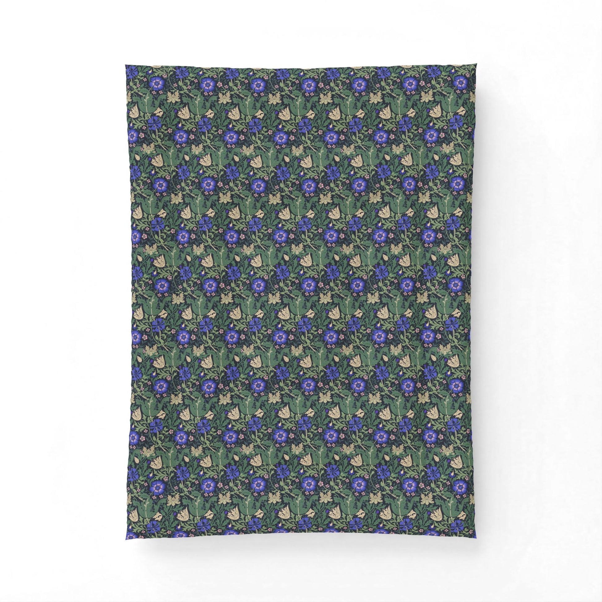 A rectangular fabric item, likely a pillowcase or small blanket, featuring a dense repeating pattern of blue flowers, green leaves, and small cream-colored rabbits on a dark teal background.