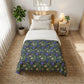 Bedroom with a floral-patterned comforter on a bed, nightstand, and plant.