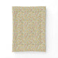 A rectangular fabric item, likely a pillowcase or small blanket, featuring a dense, all-over botanical pattern of yellow flowers and green leaves on a light beige background, shown against a plain white backdrop.