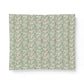 A square fabric or paper sample with an all-over vintage floral pattern in muted teal, beige, and soft orange, shown against a plain white background.