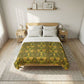 Bed with a green floral patterned comforter in a bedroom setting.