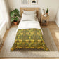 Bedroom with a bed featuring a green and yellow patterned comforter, nightstand, and plants.