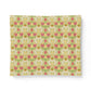 A square fabric sample or napkin featuring a vintage floral pattern with pink flowers, green leaves, and yellow accents on a cream background, displayed against a clean white backdrop.