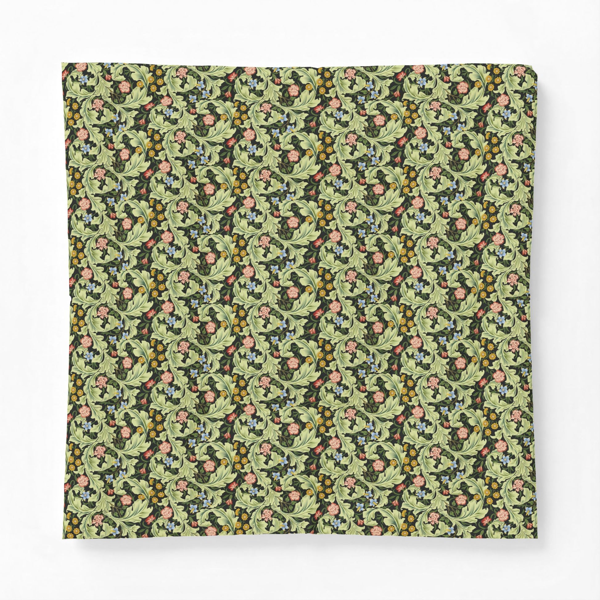 A square fabric item, likely a pillow cover or throw blanket, featuring a dense vintage botanical pattern with green leaves, pink flowers, and small yellow berries on a dark background, shown flat against a light gray backdrop.
