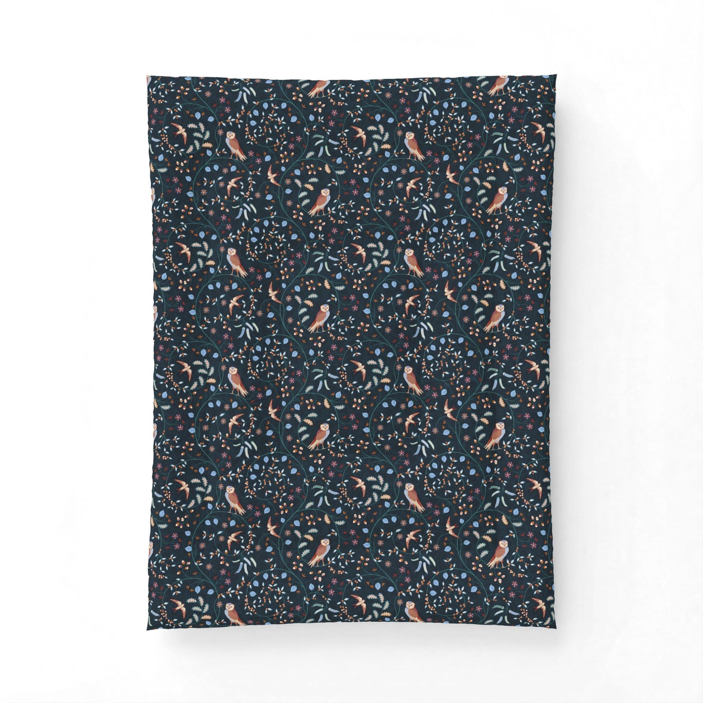 A rectangular fabric item, likely a pillowcase or small blanket, featuring a dense botanical and bird pattern on a dark navy background. The pattern includes light blue leaves, small orange and yellow flowers, and stylized birds in muted pink and brown tones.