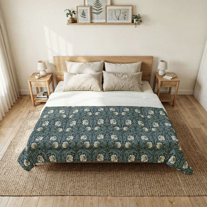 Bedroom with a bed featuring a green floral patterned quilt, wooden headboard, and side tables.