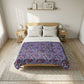 Bed with a floral patterned comforter in a bedroom setting