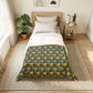 Bedroom with floral-patterned comforter on a bed, side table with lamp and books, and plants.