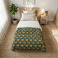 Bedroom with a bed featuring a green floral patterned comforter, nightstand, and plant.