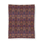 A rectangular textile product, likely a blanket or tapestry, featuring an intricate, symmetrical floral and ornamental pattern in deep purple, burgundy, and warm orange-brown tones, shown flat against a white background.