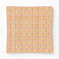 A square fabric cushion cover featuring a repeating ornate damask pattern in warm orange, yellow, and soft pink tones, shown against a plain white background.