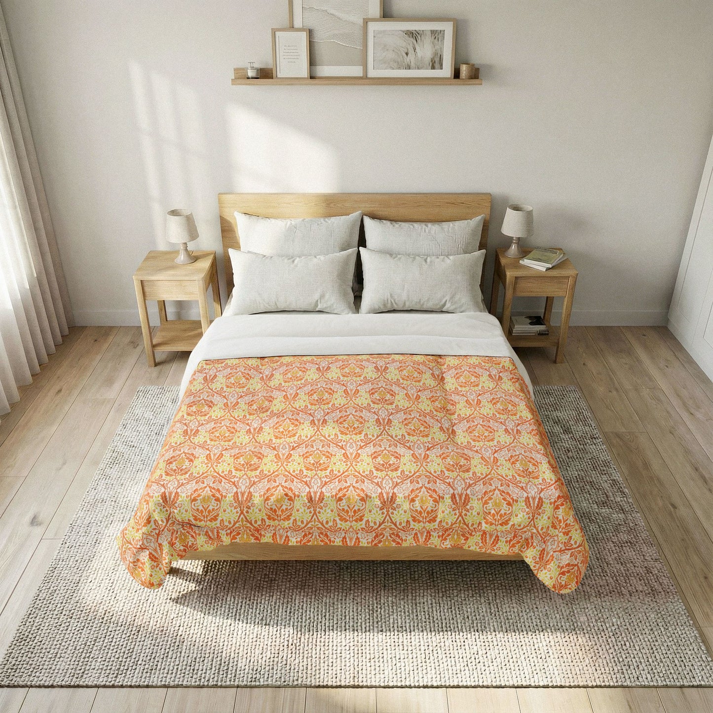 A neatly made bed in a bright, modern bedroom, featuring a patterned orange and yellow damask-style comforter over white sheets, flanked by two light wood nightstands with lamps.