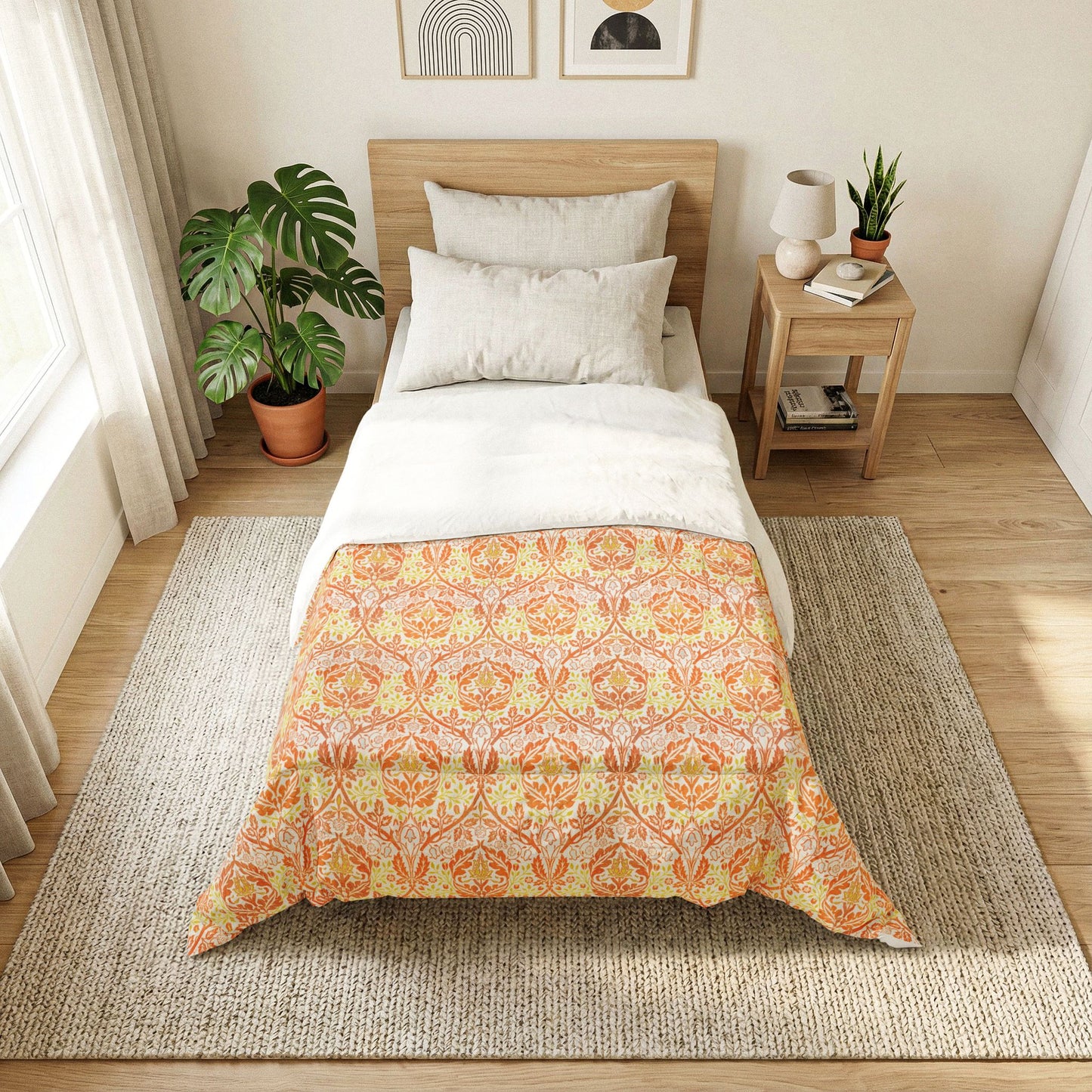 A neatly made single bed in a bright, modern bedroom. The bedding features a white top section and a lower section with a warm orange, yellow, and beige damask-style pattern.