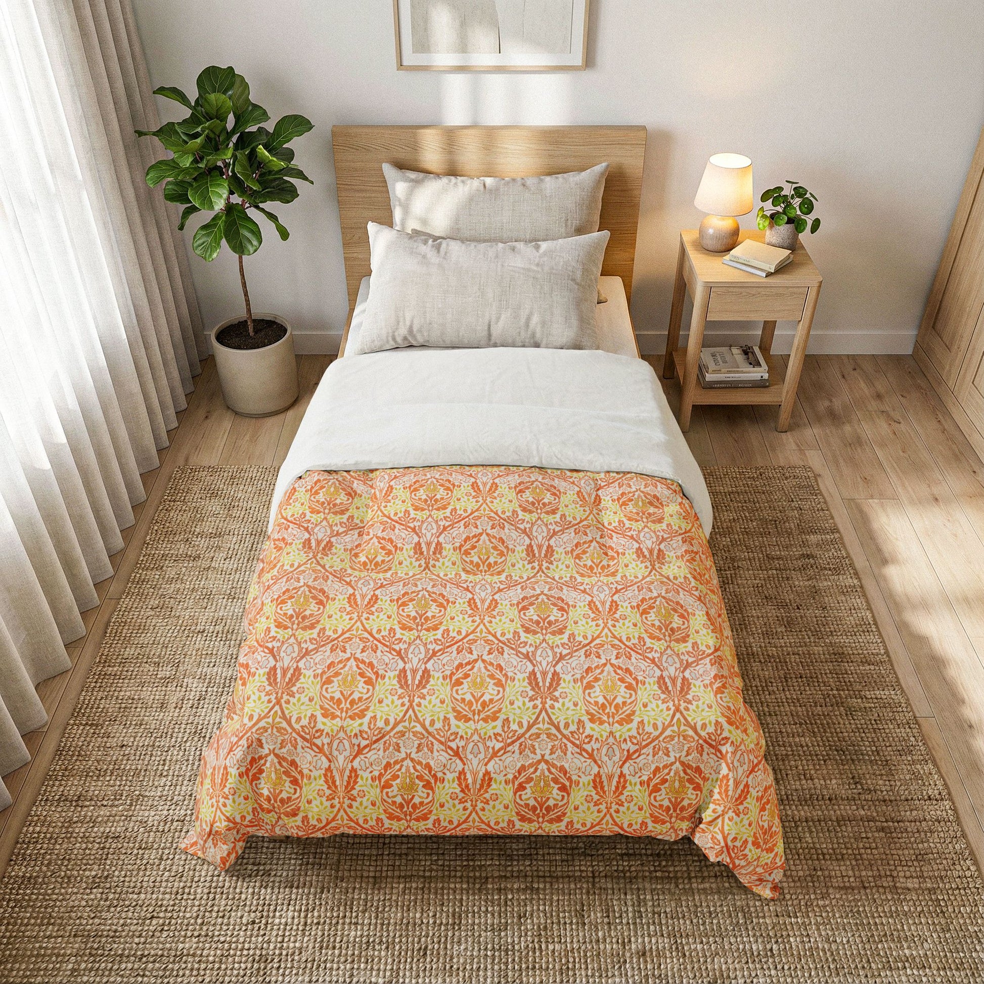 A single bed styled in a bright, modern bedroom, featuring a duvet cover with a warm orange and yellow damask pattern over white bedding. The bed is placed on a textured brown jute rug next to a wooden nightstand with a lit lamp and a potted plant.