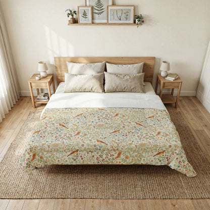 A neatly made bed in a bright, minimalist bedroom, featuring a cream-colored duvet cover with a detailed botanical and bird pattern, styled with neutral beige pillows and white sheets.