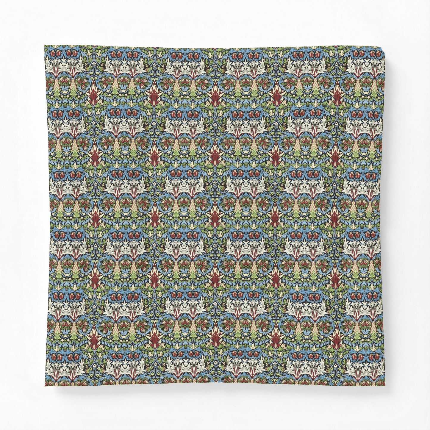 A square throw pillow featuring a dense, symmetrical floral and botanical pattern in muted blue, green, beige, and rust red tones, set against a clean white background.
