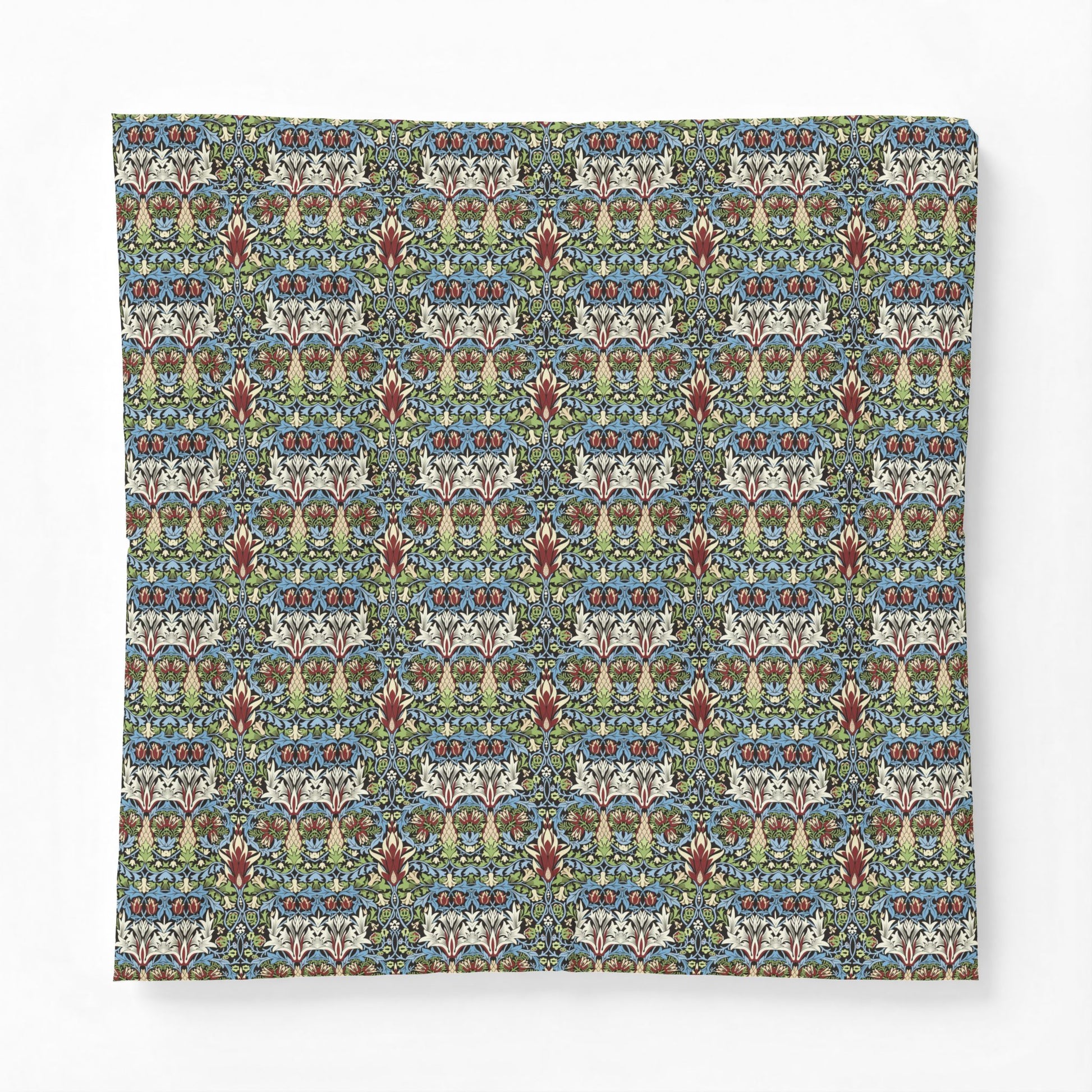 A square throw pillow featuring a dense, symmetrical floral and botanical pattern in muted blue, green, beige, and rust red tones, set against a clean white background.