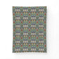 A rectangular textile or fabric panel with an intricate repeating floral and ornamental pattern in muted blue, green, cream, and red tones, shown against a plain white background.