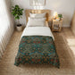 A single bed styled in a bright, modern bedroom, featuring a dark green quilt with a detailed botanical and floral pattern on the lower half and solid white on the upper half.