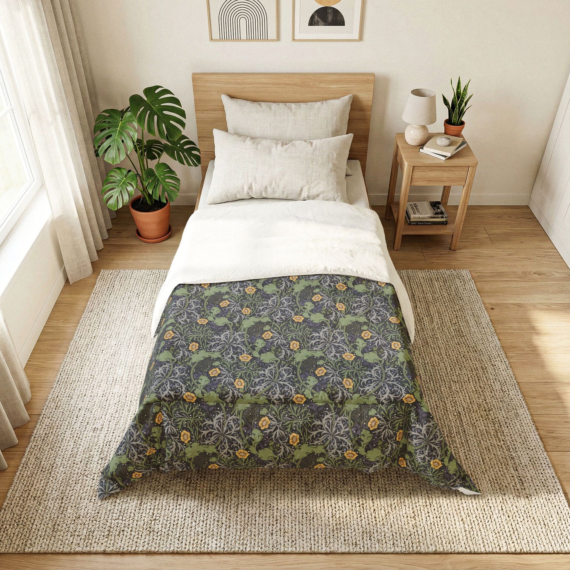 Bedroom with floral-patterned comforter on a bed, side table with lamp and books, and plants.