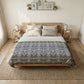 Bedroom with a wooden bed, patterned duvet, and side tables.