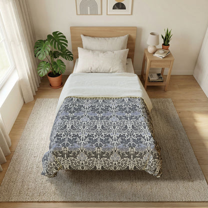 Bedroom with a bed covered in a floral-patterned comforter, nightstand, and plants.