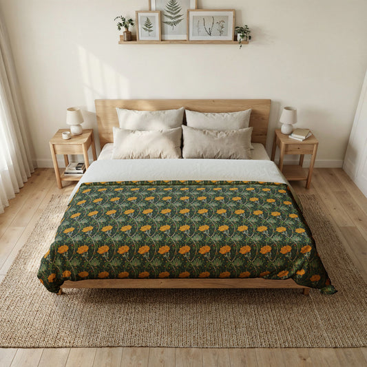 A neatly made bed in a bright, minimalist bedroom, featuring a dark green floral patterned comforter with orange flowers and a white sheet, set against a light wood bed frame.