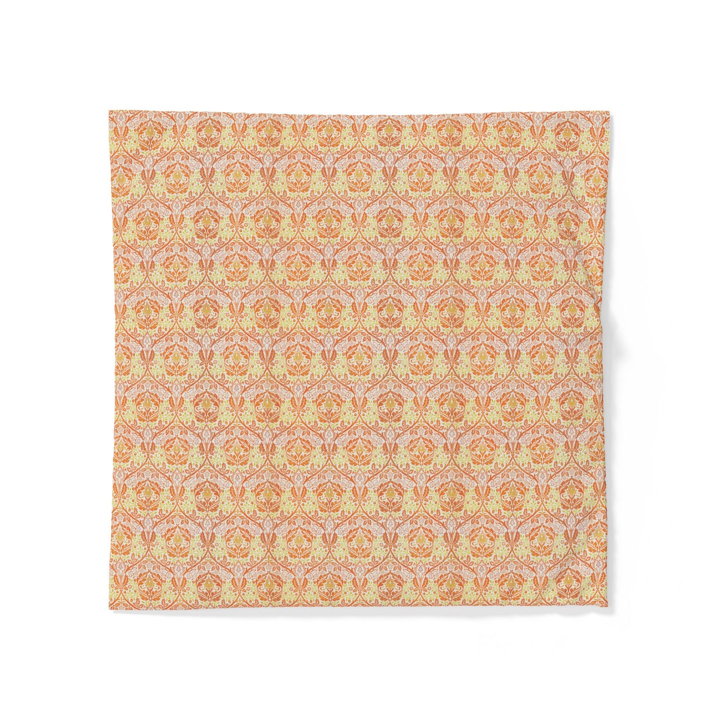 A square fabric napkin or placemat featuring an intricate repeating damask pattern in warm tones of orange, yellow, and soft pink on a white background.