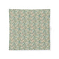 A square fabric bandana featuring a dense, vintage-style floral and botanical pattern in muted teal, sage green, beige, and soft rust orange, displayed flat against a clean white background.