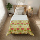 Bedroom with a William Morris & Co floral comforter on a bed, nightstand, and plant.
