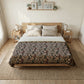 Bedroom with a wooden bed, floral comforter, and side tables.