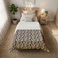 Bedroom with floral comforter on a bed, nightstand, and plant.
