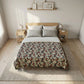 Bedroom with floral patterned duvet cover on a bed, wooden nightstands, and framed pictures on the wall.