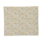 A square fabric item, likely a placemat or napkin, featuring a dense vintage-style botanical and bird pattern on a light cream background. The pattern includes muted green leaves, small blue and pink floral details, and scattered brown birds, all set against a clean white background.