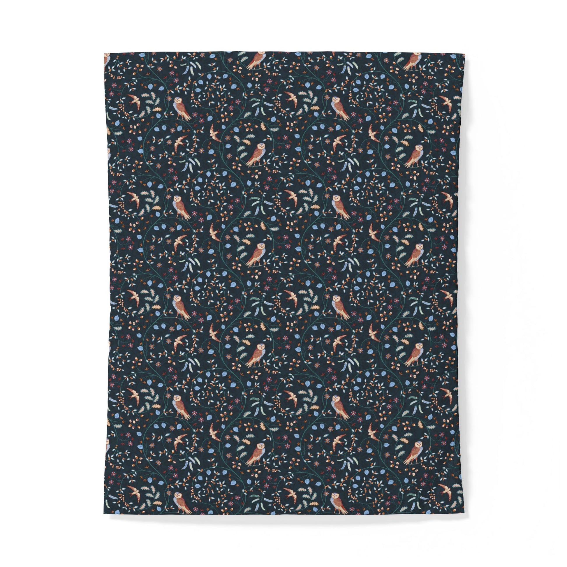 A rectangular fabric item, likely a blanket or tapestry, featuring a dense botanical and bird pattern on a dark navy background. The pattern includes small peach-colored birds, light blue flowers, and green leaves.