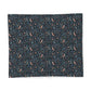 A square fabric sample or napkin featuring a dense botanical and bird pattern on a dark navy background, with small peach birds, blue leaves, and light blue dots.