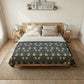 Bedroom with a bed featuring a floral comforter, wooden headboard, and side tables.