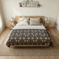 Bedroom with a bed featuring a patterned comforter, wooden headboard, and side tables.