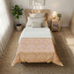 Bedroom with a bed featuring a floral comforter, nightstand, and plants.